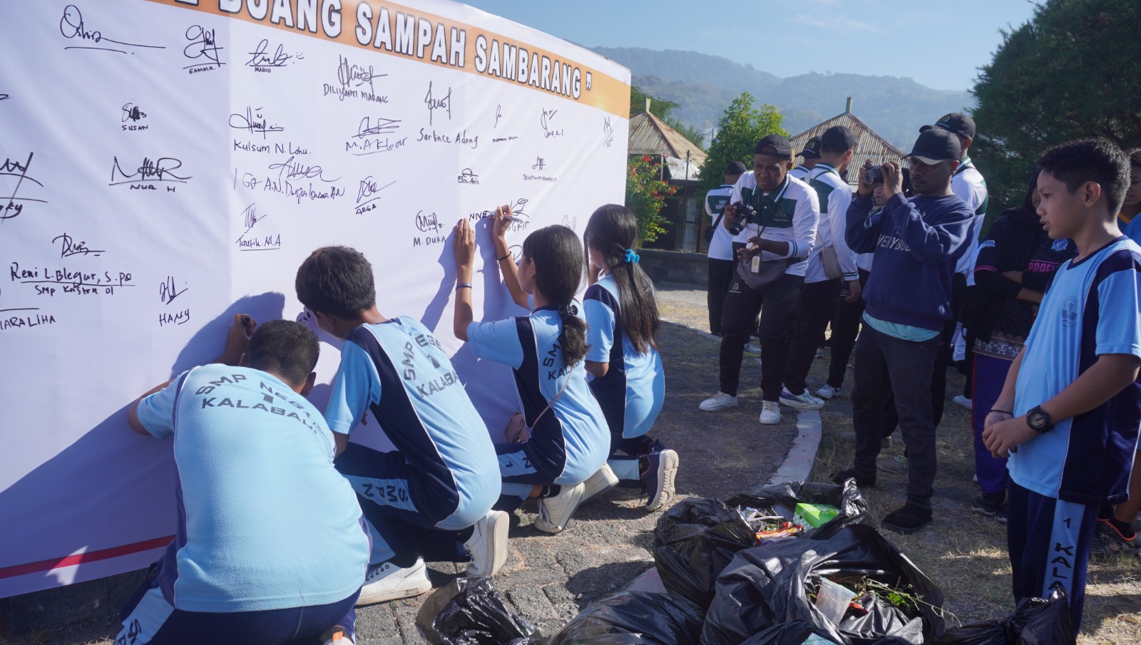 Dipelopori Kejaksaan Negeri Alor, sejumlah siswi menanda tangani komitmen jangan buang sampah sembarang di ujung aksi tanam pohon kenari dan pungut sampah di Kawasan Relakmase Pantai Dulionong Kota Kalabahi, Kabupaten Alor, Sabtu (20/07/2024). FOTO:ITM