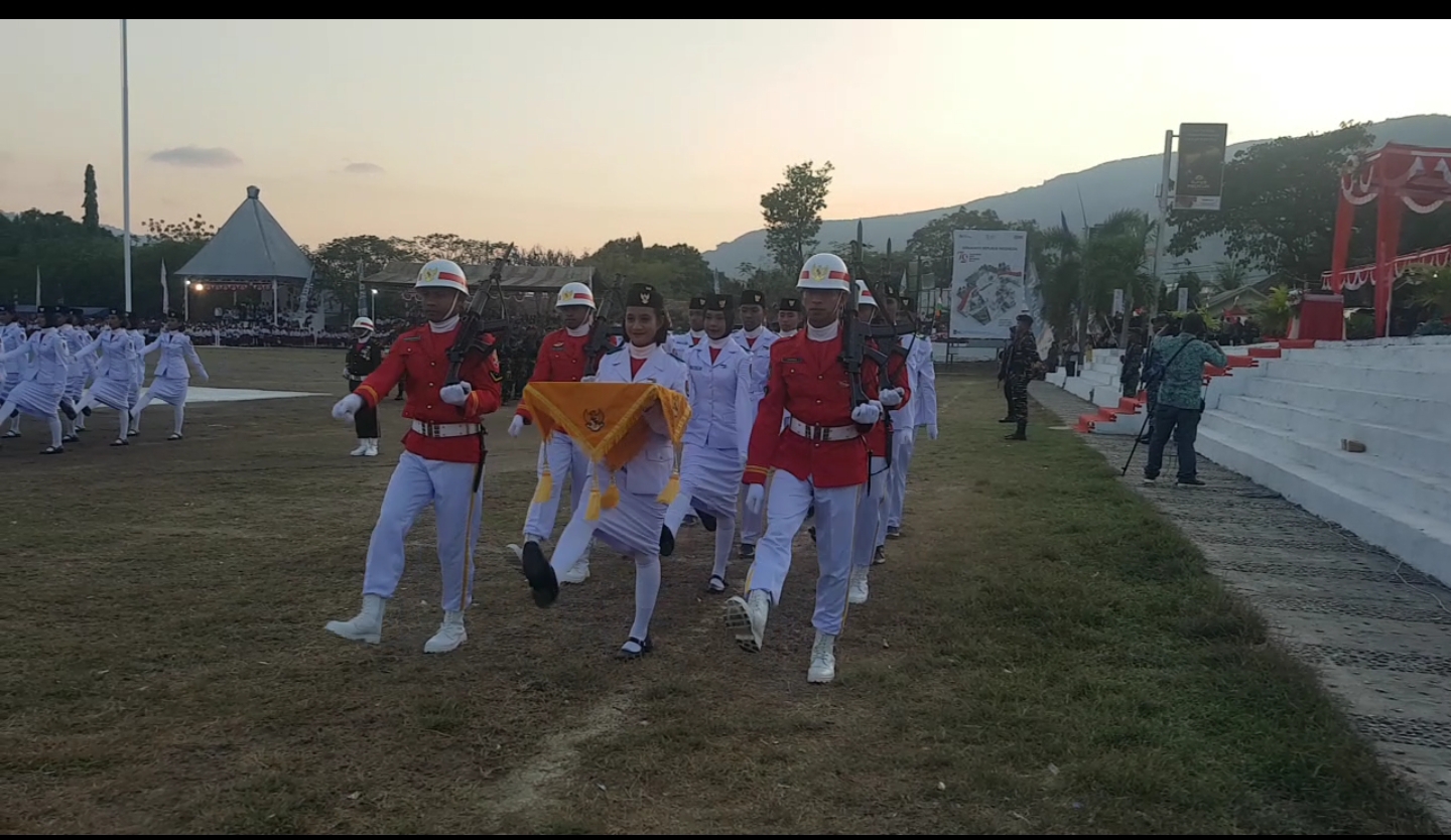 Paskibra Alor 2024 sedang melaksanakan tugas penurunan bendera merah putih pada upacara penurunan bendera dalam rangka HUR Ke-79 Republik Indonesia. Nampak pembawa baki Dwi Patricia siswi SMA Kantolik ST Yoseph Kalabahi ada dalam barisan 8 prosesi menuju penurunan bendera. FOTO:MORISWENI/RADARPANTAR.com