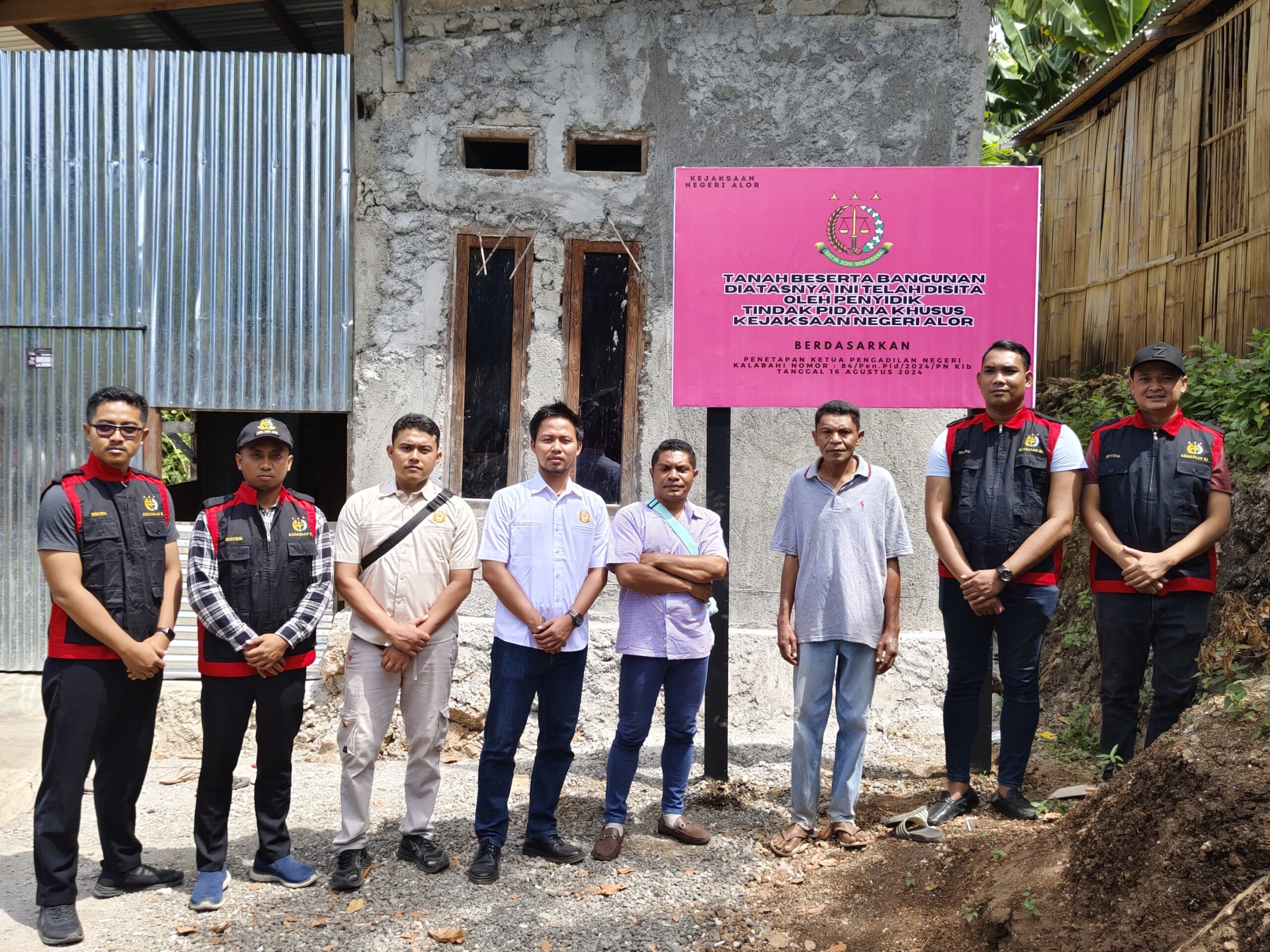 Penyidik Kejaksaan Negeri Alor dalam satu sesi foto dengan latar bangunan milik Bendahara BOK Puskesmas Apui 2023 yang telah dipasang papan penyitaan oleh kejaksaan. FOTO:DOK