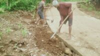 salah seorang tukang sedang memperbaiki bagian jalan yang rusak di jalan ruas Latuna-Boloang. FOTO:DOK