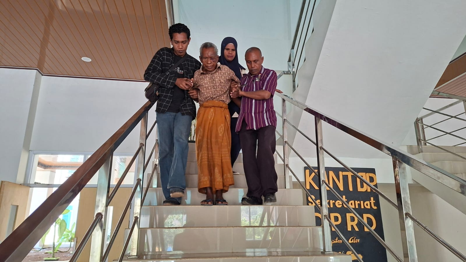 Korban Lakalantas oleh oknum anggota DPRD Alor, Hasan Jaku (78) dituntun anggota keluarga turun melalui tangga lantai dua gedung DPRD usai bersama keluarga menemui Pimpinan DPRD setempat. FOTO: OM MO/RP