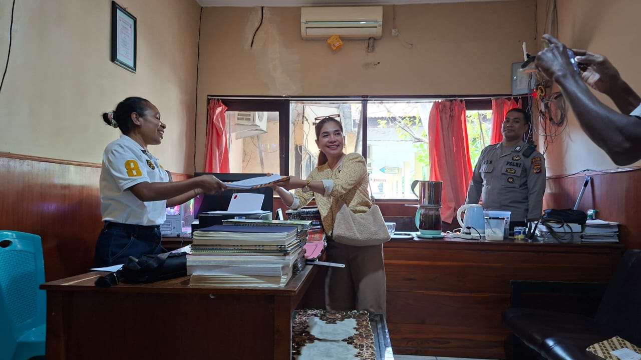 Aisyah sedang menyerahkan pengaduan kepada salah seorang staf tata usaha pimpinan di Polres Alor. FOTO: OM MO/RP
