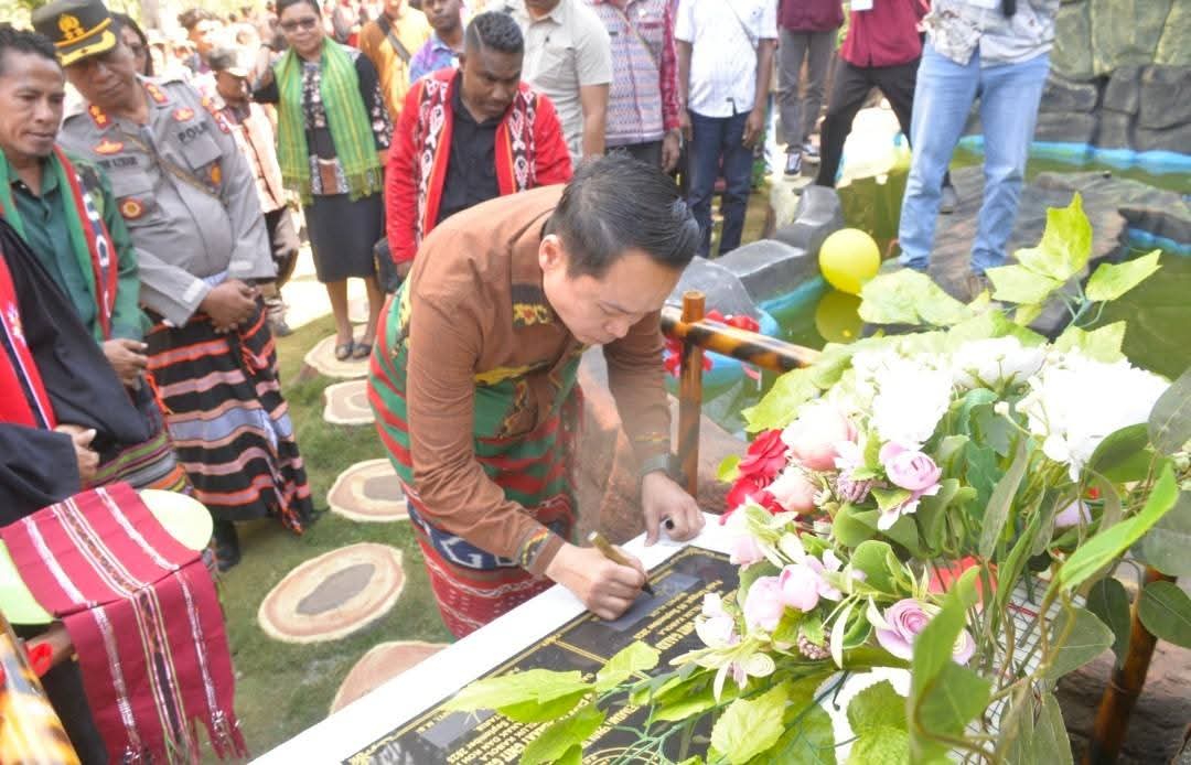 Mengenakan sarung adat, Wakil Bupati Alor Rocky Winaryo, SH, MH menanda tangani prasasti pertanda diresmikannya Gedung Gereja GMIT Galed Otvai. FOTO:Humaskab Alor
